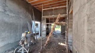 Foto de uma área interna em construção com paredes de concreto expostas.