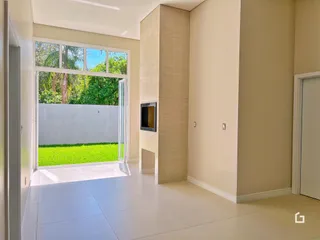 A sala de estar possui portas de vidro que dão acesso a um gramado externo.