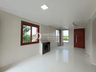 Sala de estar com piso de cerâmica branca e janela de madeira.