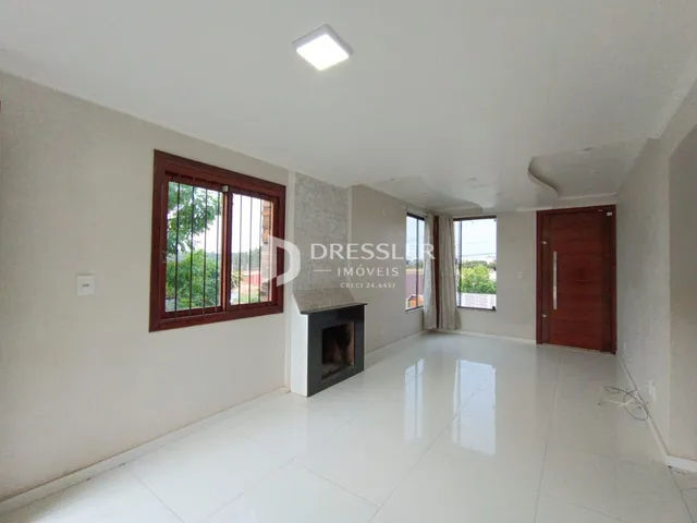 Sala de estar com piso de cerâmica branca e janela de madeira.