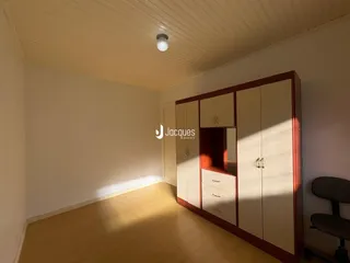 Ambiente interno de uma sala com piso de madeira e armário embutido.
