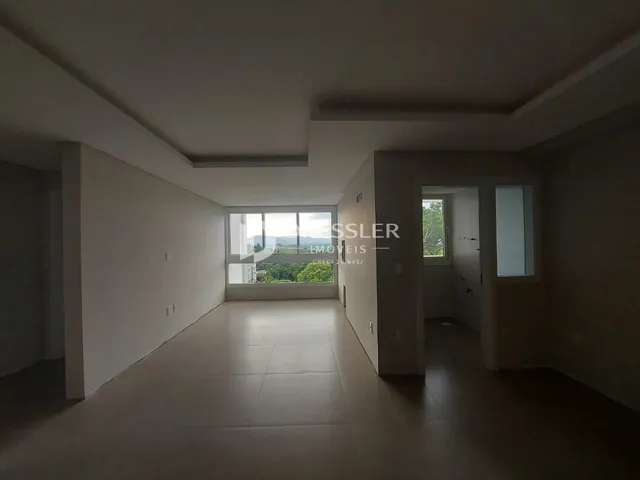 Corredor interno de uma residência com piso claro e paredes brancas.