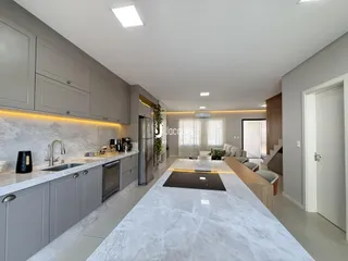 Esta é uma foto de uma cozinha moderna com armários cinzas e bancadas de mármore claro.