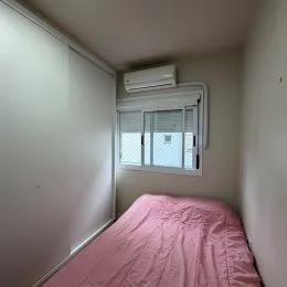 Quarto com cama e roupa de cama rosa.