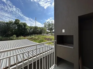 Vista da fachada de uma residência com telhado de metal e grade de segurança.