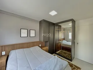 Quarto com cama e armário de vidro em um imóvel.