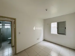 Interior de uma sala com piso de cerâmica e janela.