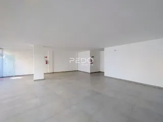 Vista interna de um corredor amplo e iluminado em um imóvel.