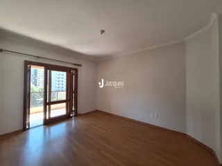 Interior de uma sala com piso de madeira e porta de vidro.