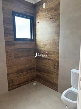 Foto de um ambiente interno com revestimento de madeira escura e piso claro.