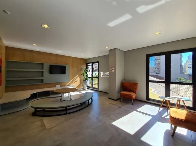 Sala de estar com piso de cerâmica e paredes em madeira clara.