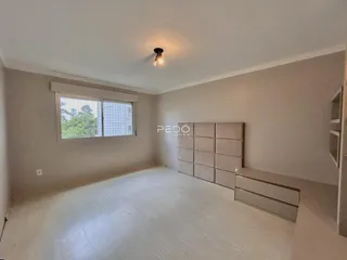 Um quarto amplo com paredes claras e piso claro em uma residência.