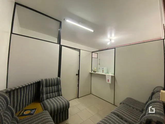 Foto de uma sala interna com paredes brancas e portas de correr.