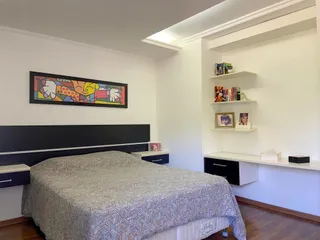 Foto de um quarto com cama e cabeceira escura em um imóvel.