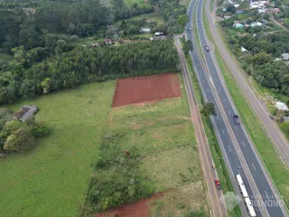 Vista aérea de uma propriedade com área de campo e estrada no entorno.