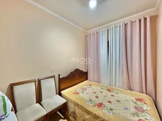 Quarto com cama de madeira e cortinas rosa e branco.