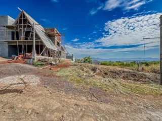 Fachada de uma casa em construção em Lajeado, Brasil, com terra e estrutura exposta.
