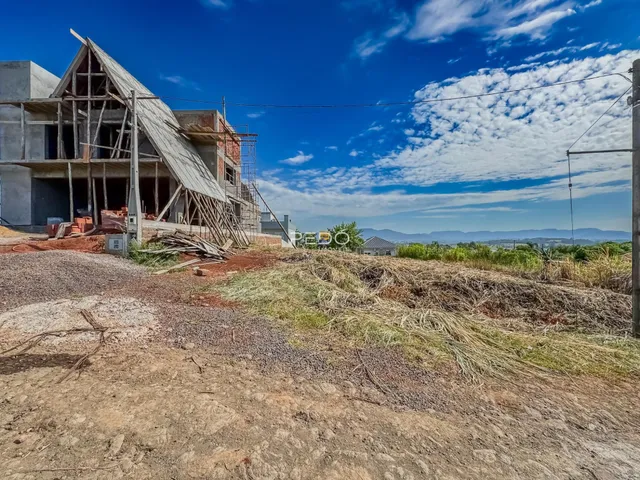 Fachada de uma casa em construção em Lajeado, Brasil, com terra e estrutura exposta.