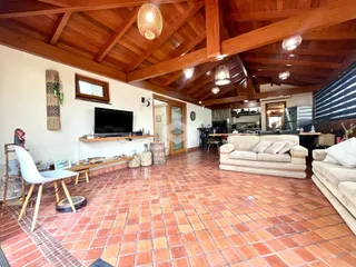 Sala de estar com piso de tijolo vermelho e teto de madeira.