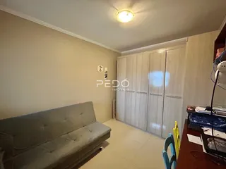 Sala de estar com sofá e armário branco na residência.