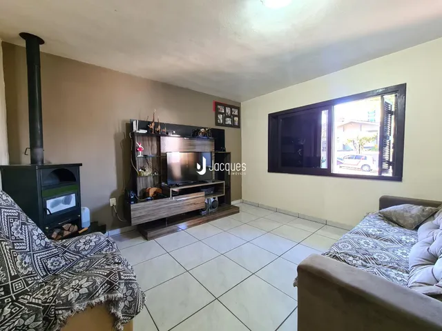 Sala de estar com lareira e grande janela no ambiente.