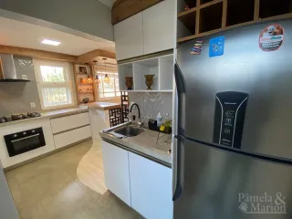 Cozinha moderna com armários brancos e eletrodomésticos de aço inoxidável.