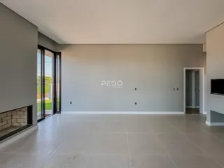 Sala de estar ampla com piso de cerâmica e porta de vidro.