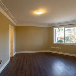 Sala de estar com piso de madeira e janela.