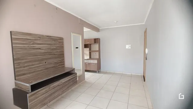 Quarto com cabeceira de madeira e piso de cerâmica.