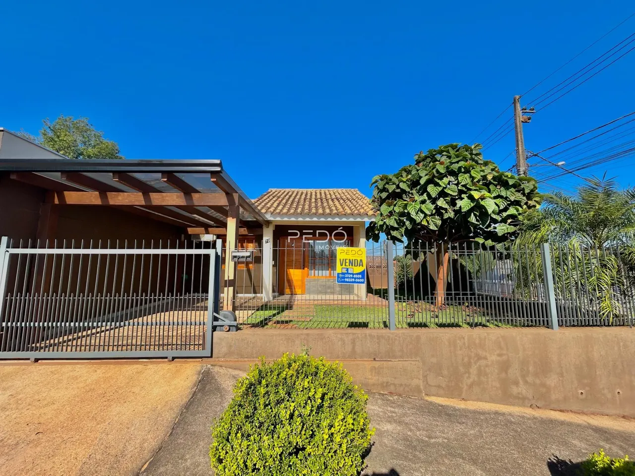 Fachada de uma casa em Lajeado, Brasil, com cerca e vegetação.