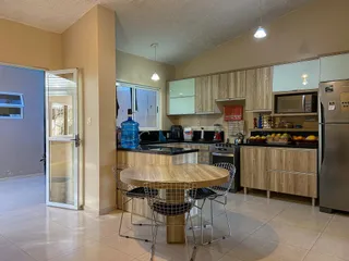 Uma cozinha moderna com armários de madeira e bancadas escuras.