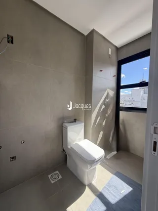 Foto de um banheiro interno com piso de cerâmica e vaso sanitário branco.