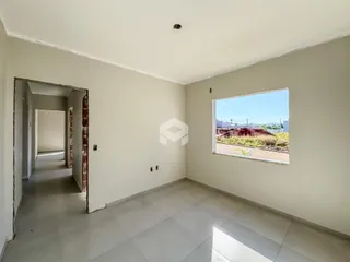 Hall de entrada com piso de cerâmica e janela.