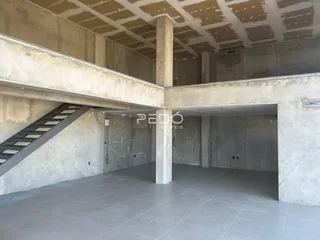 Foto de uma estrutura interna de concreto aparente com escadaria.