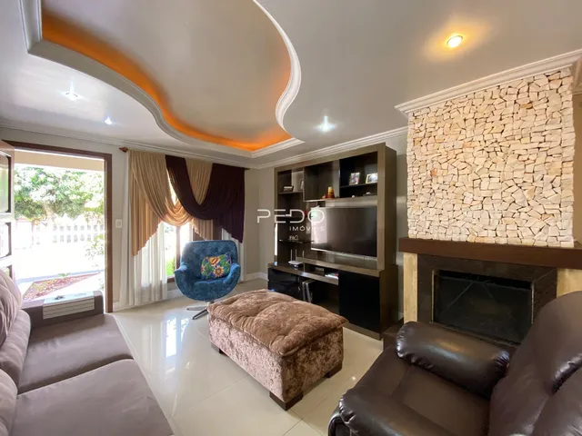 Sala de estar com decoração moderna e parede de pedra na Lajeado.