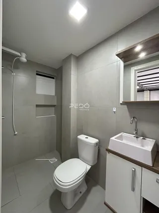 Banheiro moderno com piso cerâmico e bancada de madeira.