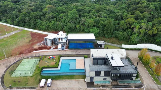 Vista aérea de uma propriedade com piscina e quadra de tênis em Lajeado.