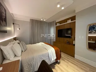 Quarto com cama grande e painel de madeira na parede.