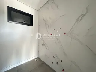 Parede com revestimento de mármore e uma janela escura em um ambiente interno.