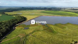 Vista aérea de uma propriedade com um lago cercado por campos verdes.