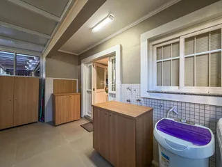 Foto de um corredor interno com armários e uma janela em uma residência.