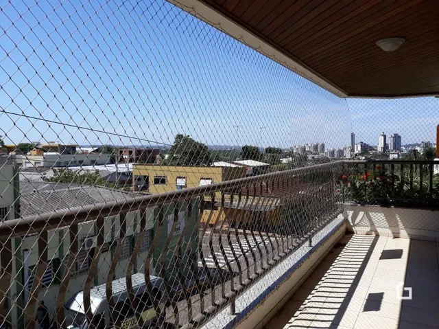 Vista externa de uma propriedade com grade de segurança e muro.