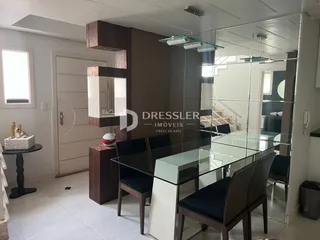 Vista de uma sala de jantar com mesa de vidro e divisórias de vidro.