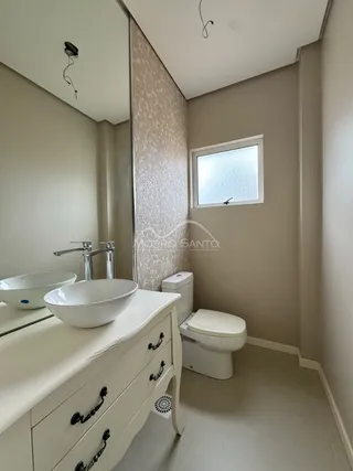 Banheiro com bancada de pia e vaso sanitário branco.