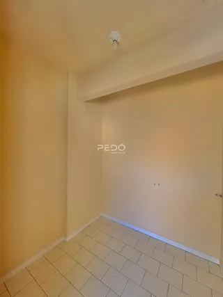 Hall de entrada com piso de cerâmica clara e paredes em tom bege.