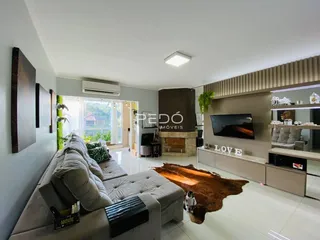 Sala de estar moderna com sofá e lareira em um apartamento no Brasil.