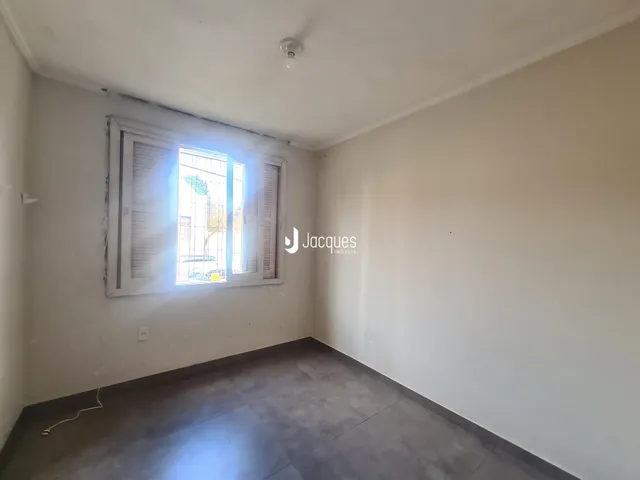 Foto de um cômodo interno com paredes brancas e piso cinza.