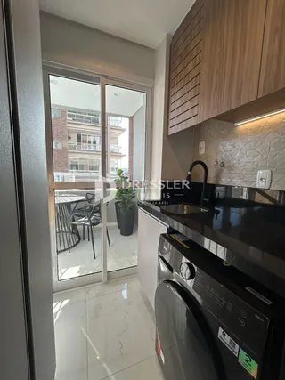 Um corredor interno com acesso a uma cozinha moderna.