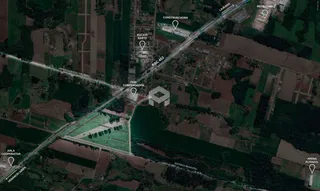 Vista aérea de uma propriedade rural com áreas de vegetação e campos.