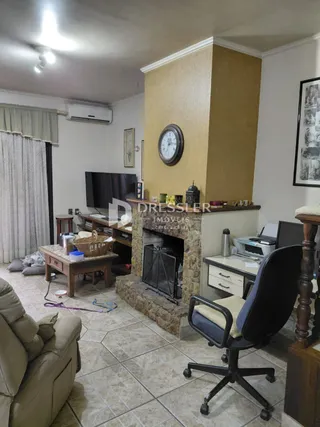 Sala de estar com piso de cerâmica e lareira em um imóvel no Brasil.